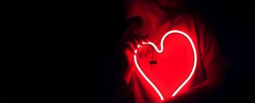 a heart shaped neon sign in the dark