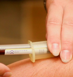 person injecting syringe