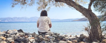 A person sits and enjoys the scenic seaside view.
