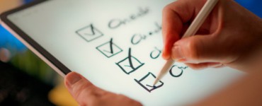 A hand marks off items on a checklist.