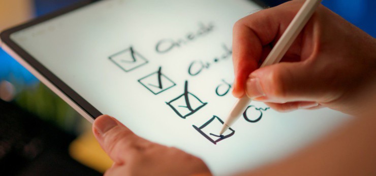 A hand marks off items on a checklist.